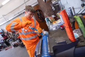 Apprentice repairing water pipe in workshop